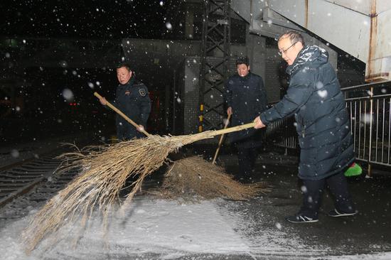 新鄉(xiāng)車務(wù)段新鄉(xiāng)車站干部職工對(duì)站臺(tái)旅客登乘處進(jìn)行清掃作業(yè)，確保旅客乘降安全。
