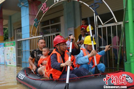 图为平果供电局抢修人员划着橡皮艇接送被困幼儿园的孩子。　冉袖言 摄