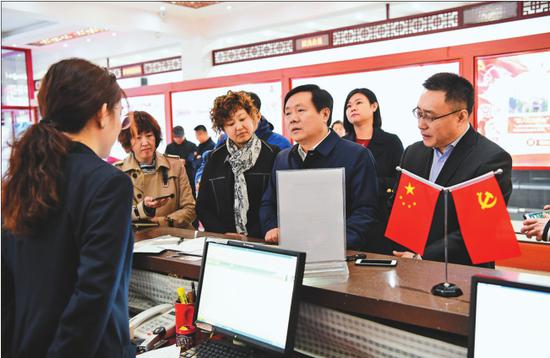 梁野(右三)切身体验办理就业失业登记证流程。 吴迎本报记者邢汉夫摄