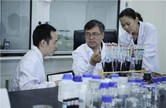大庆油田科研工作者伍晓林（中）在做表面活性剂研制实验（6月20日摄）。新华社发（赵永安 摄）