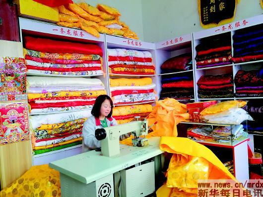 3月19日，刘绵海的寿衣店内，一名员工正在加工寿被。记者黄海波 摄