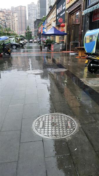 当天爆炸的地点,三个圆形的窨井盖被掀翻。成都商报 图