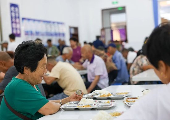 8月11日,居民在吉林省舒兰市舒兰三中安置点的食堂吃饭