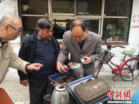 王仲魁正在为社区居民维修家电。 杨旭东 摄