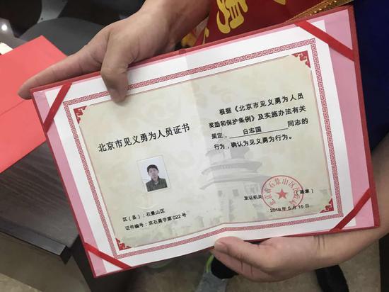 北京市民政局见义勇为处处长柴珠峰给白志国、高金明颁发证书和奖金。新京报记者 张静雅 摄