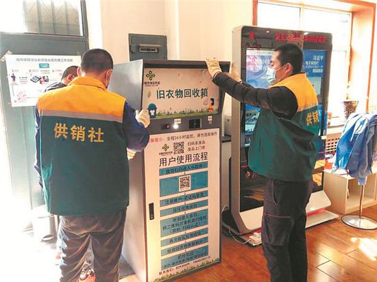 工作人员将旧衣物智能回收箱摆放到指定地点。