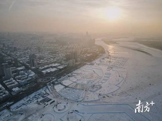 哈尔滨城区被冰雪覆盖，人们在结冰的松花江上游玩