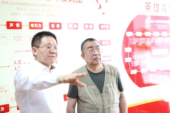 　　颜建国向郭仲华介绍英雄儿女品牌联盟商业运行模式和发展规划