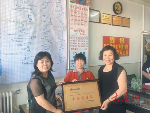 大庆福彩中心工作人员为投注站送去奖牌。