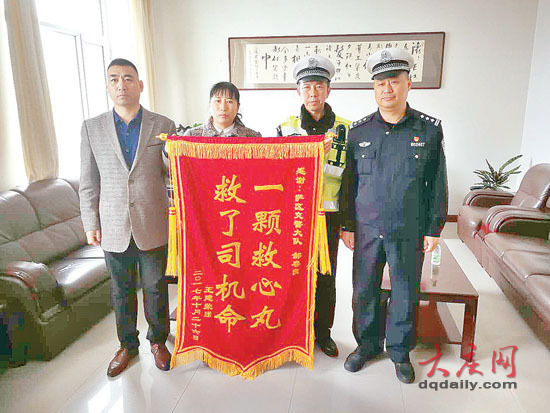 女司机王女士(左二)为了表达感激之情,为交警郝春良(右二)送来了锦旗。