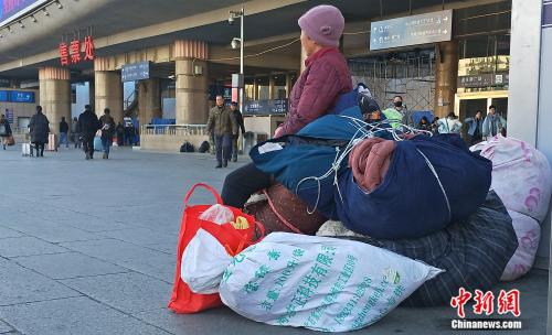 资料图：正在车站外候车的旅客。姚露 摄