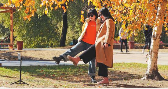 市民在哈尔滨太阳岛上赏秋留影。 本报记者张澍摄