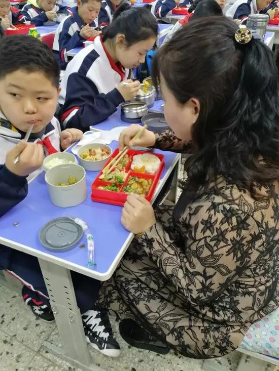 与此同时，在六年四班，副校长白晶和宋云洁主任，边吃饭边和学生聊天——