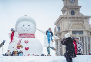 游客在哈尔滨与大雪人“雪中共舞”。哈尔滨日报记者 陈南摄