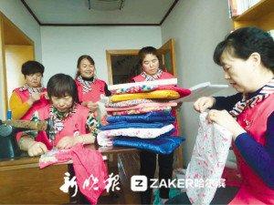 王春艳（右一）与志愿者给小区休息座椅缝垫子