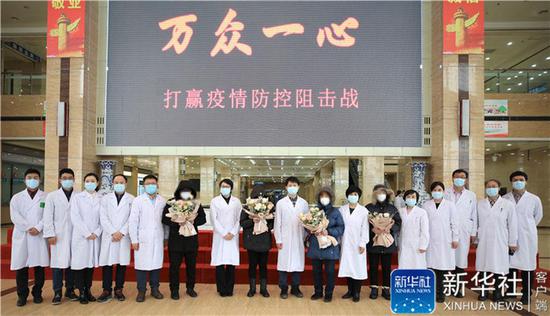 ↑3 月 26 日上午，黑龙江省新冠肺炎重症救治中心内，最后 4 名患者顺利完成医学隔离观察。出院回家前，医护人员和患者在一起合影。新华社发