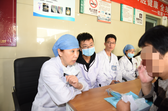 口腔内科主任王秀梅教授(左1)对患者进行问诊