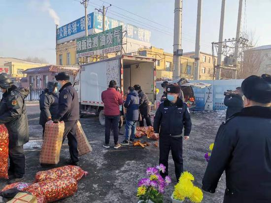 执法人员取缔冥纸冥币销售摊位现场。