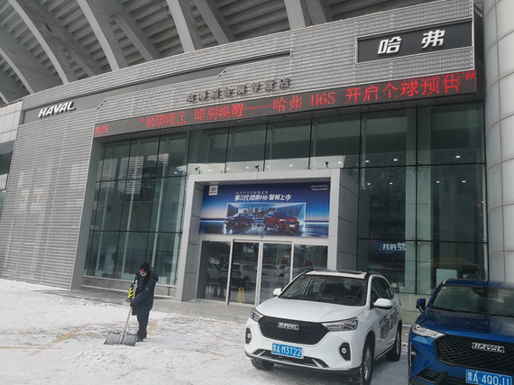 工作人员正在扫雪,还不时提醒进店的客人“雪地路滑,注意脚下”