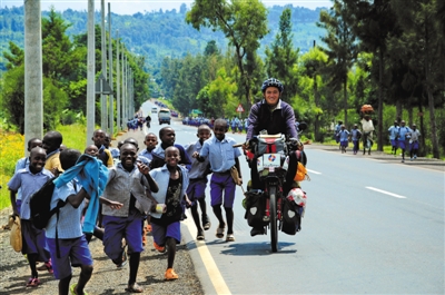 在乌干达，放学的孩子们追着杜风彦的自行车一起跑。受访者供图