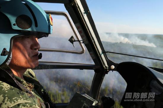 5月21日，武警森林指挥部直升机支队机长张英海驾驶直升机观察火情。韩兴华摄