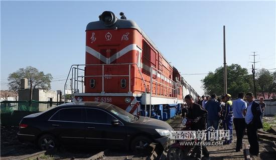 轿车被货运列车平推出近20米远后横在铁轨上。