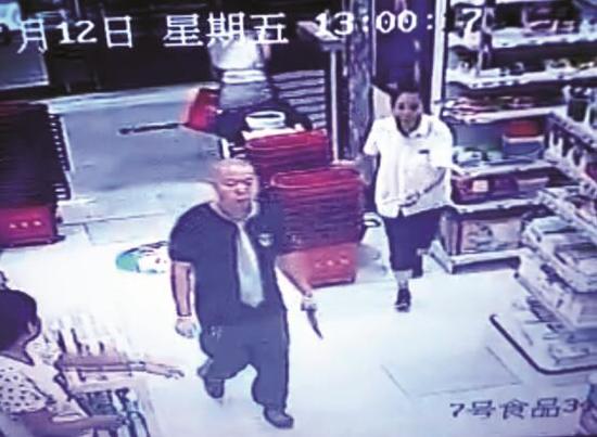 男子持刀进入超市，女服务员上前阻挠。