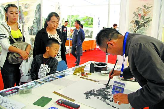 市民在南京画家杨主旺的展厅前观看创作