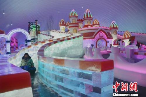 图为游客在哈尔滨冰雪大世界打冰滑梯，欢度“十一”假期。