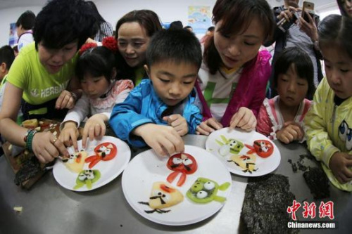 资料图　志愿者与南京留守儿童共同制作富有创意的水果拼盘。泱波 摄