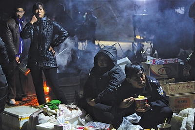 昨晚，爱心群众带来包子、馒头、热汤等食物，参加救援的警察正在吃晚饭。