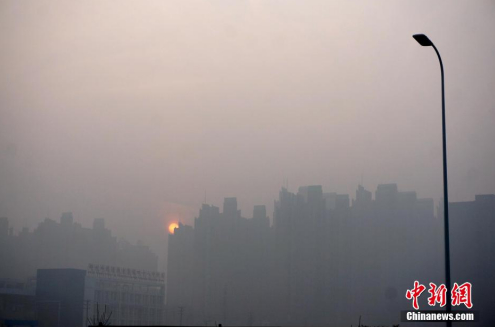 资料图： 河南郑州雾霾笼罩着的高楼大厦。 中新社记者 王中举 摄