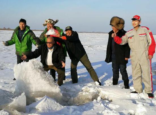华通丰田赛事勘路车队成员在勘路中与松花江上的冰排合影
