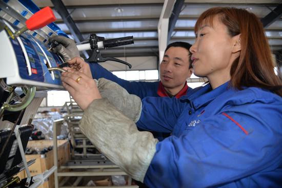 铁力经济开发区（省级）玉梅农机公司员工正在检验即将出厂的水稻插（摆栽）秧机