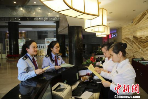 资料图: 厦门国税工作人员深入营改增企业宣传相关政策。曾霄 摄