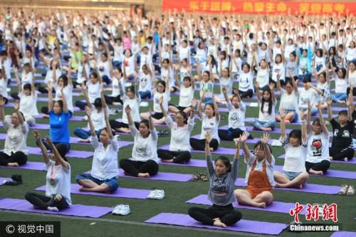 2017年5月19日,在重庆铁路中学,千余名高三学生通过在操场上练习瑜伽,来缓解高考前的焦虑和疲劳。风 摄 图片来源:视觉中国