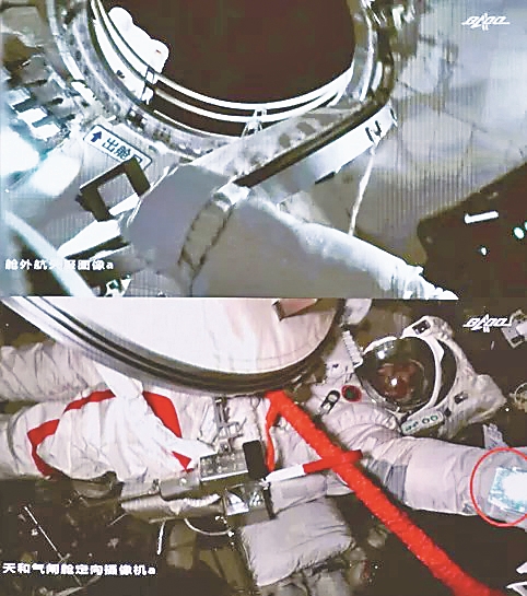 航天员佩戴舱外服反光镜出舱。
