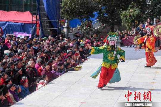 众人围观地方傩戏表演。　杨华峰　摄