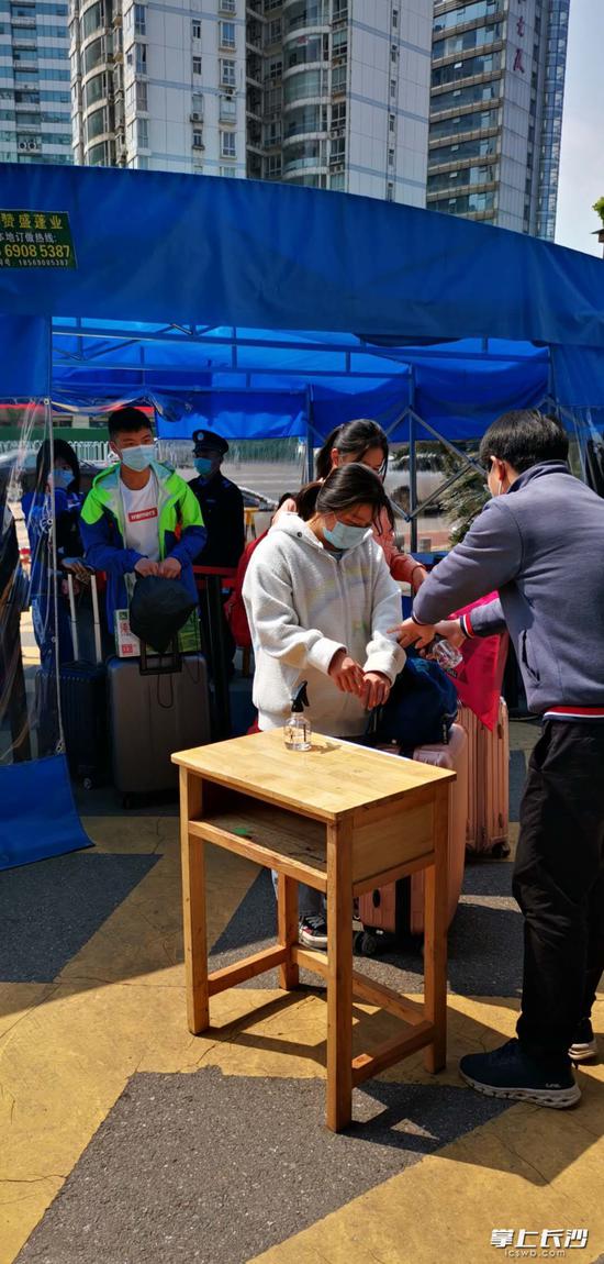 长沙市十五中学子进校测体温再消毒。