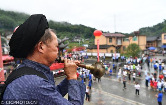 ↑在湖南省湘西土家族苗族自治州花垣县双龙镇岩锣村西瓜节活动现场，民间艺人在吹唢呐。CICPHOTO/龙恩泽 摄