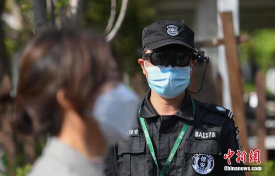 资料图:一位安保人员通过智能AR眼镜为游客测体温。 中新社记者 王刚 摄
