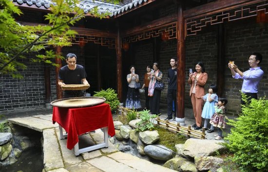 游客在常宁市省级文物保护单位三角塘镇双湾村刘家大院，观看市级非物质文化遗产项目“七醋”制作技艺展演