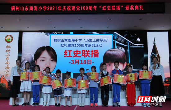 枫树山东南海小学校长与书记为获得红史联播“十佳作品”的同学颁发奖杯与证书。