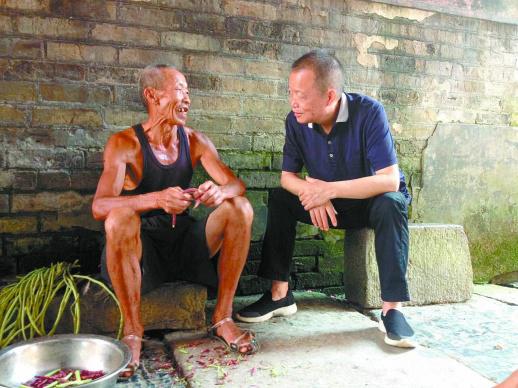 胡彬彬(右)在湖南永州与村民交谈(2017年7月25日摄)。 新华社发