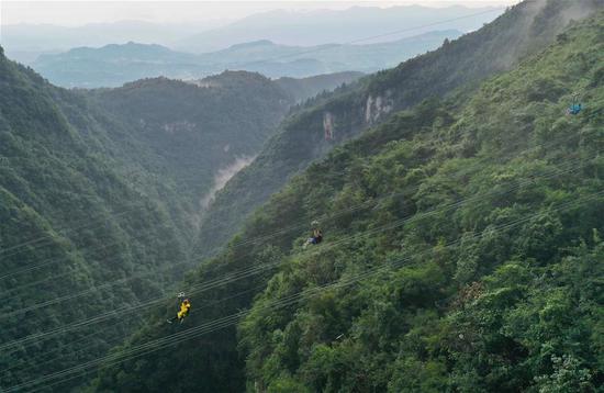 8月9日，游人在湖南张家界大峡谷景区体验高空滑索（无人机照片）。吴勇兵 摄