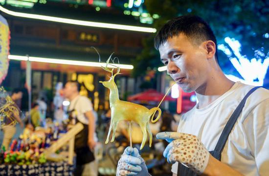 ▲ 6 月 3 日晚,长沙,廖师傅吹制的梅花鹿已逐渐成形。