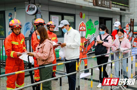 国庆期间，张家界市消防救援支队指战员向游客发送消防宣传单。