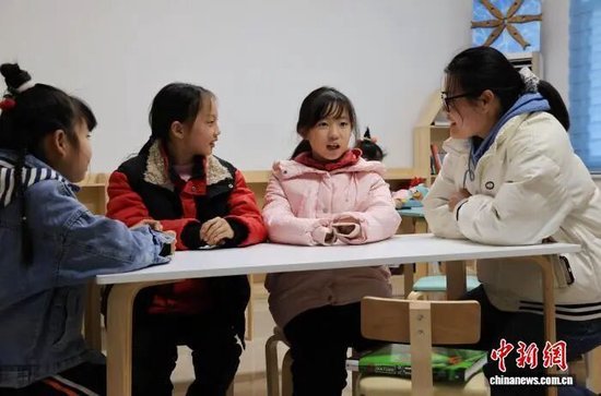 志愿者在“妈妈工厂”辅导员工的孩子学习。吴勇兵 摄