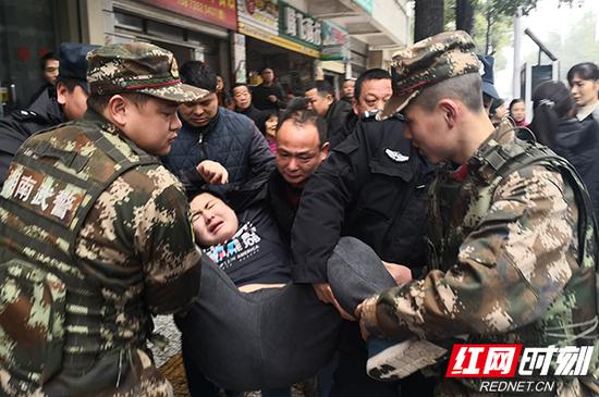武警郴州支队官兵在群众帮助下将男子转移上巡逻车。