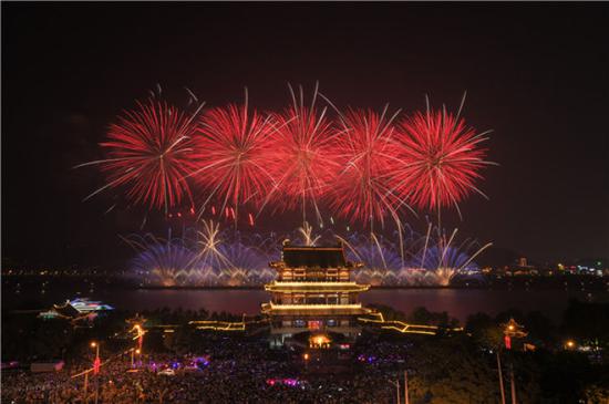  湖南长沙橘子洲的焰火与长沙城区的杜甫江阁交相辉映（5月1日摄）。新华社发（陈泽国摄）